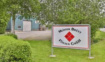 Firmenschild von Meister Brütt Fliesen vor Firmengelände